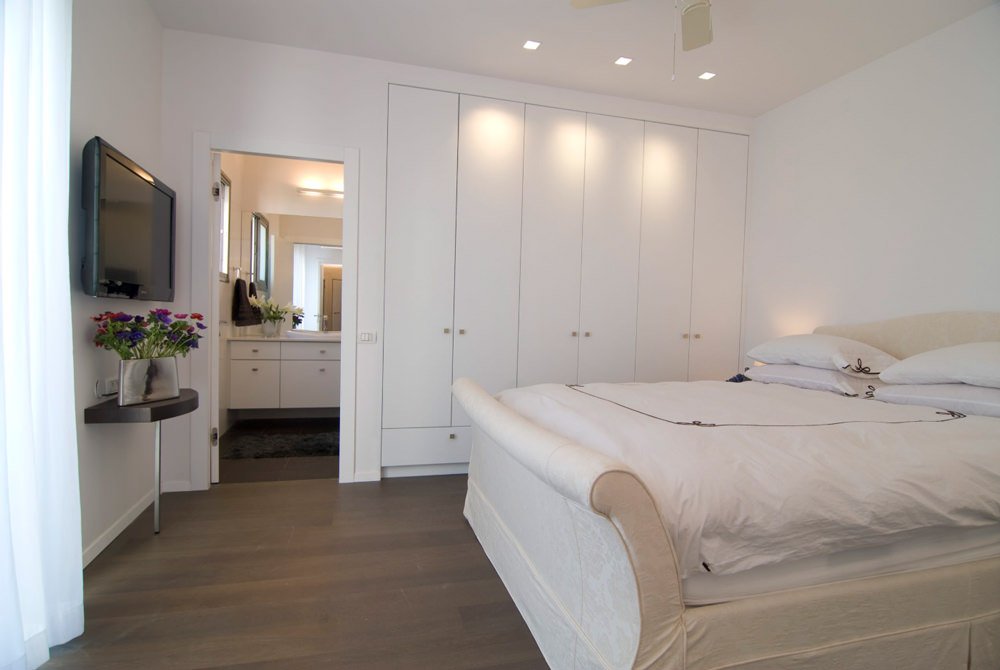 Elegante camera da letto, stile contemporaneo, con armadi a muro in cartongesso. Tv e faretti da incasso nel soffitto 