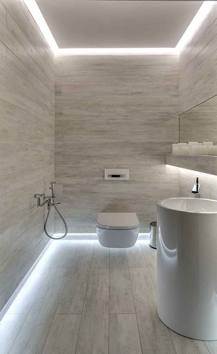 Piccolo bagno rivestito in lastre di ceramica effetto legno con una particolare illuminazione perimetrale sul pavimento e soffitto - immagini bagni moderni piccoli e originali