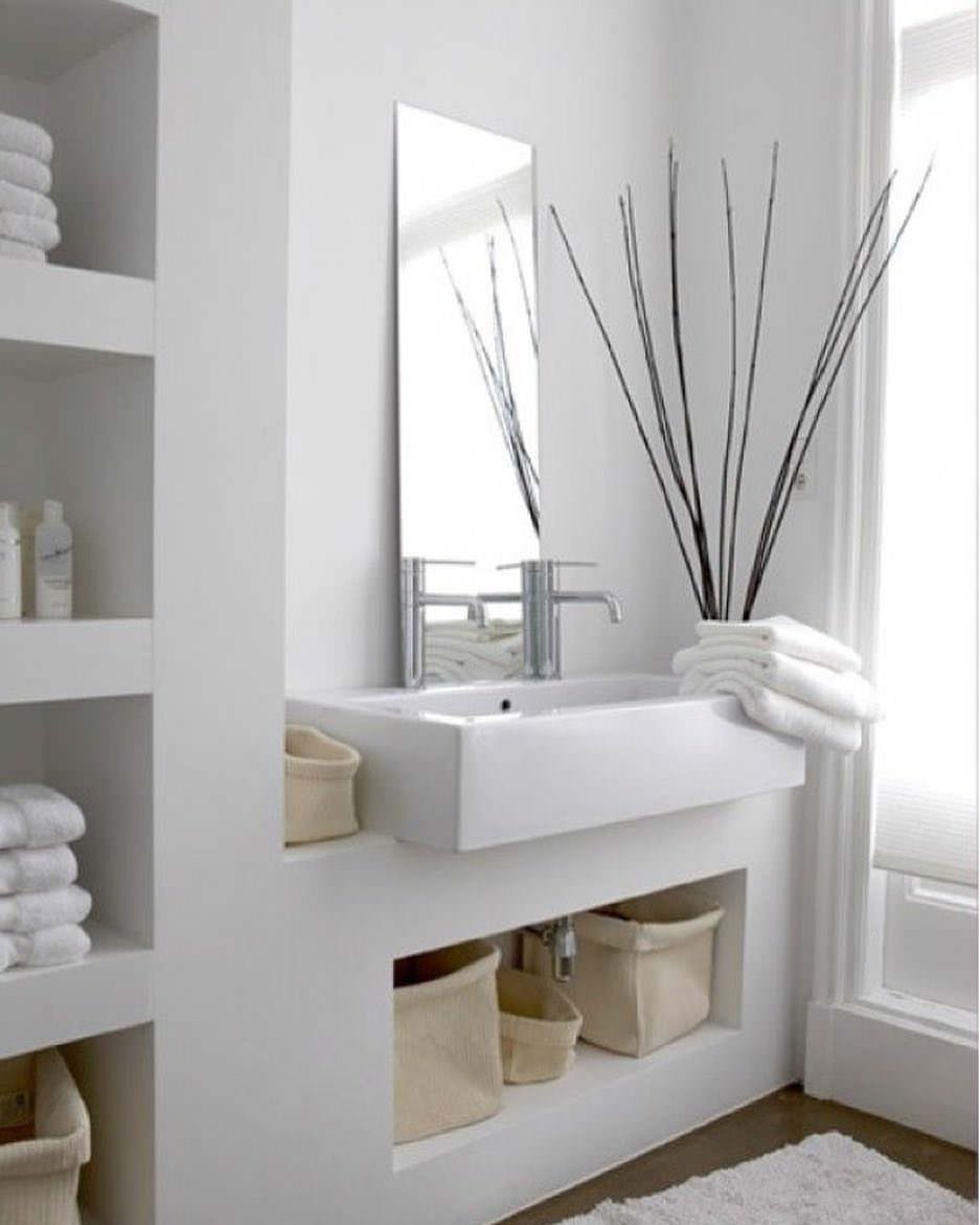 Mobile e nicchie in muratura verniciata in bianco per questo bagno elegante e di grande carattere. Molto interessante l'uso dello specchio alto e stretto, appoggiato al lavandino.