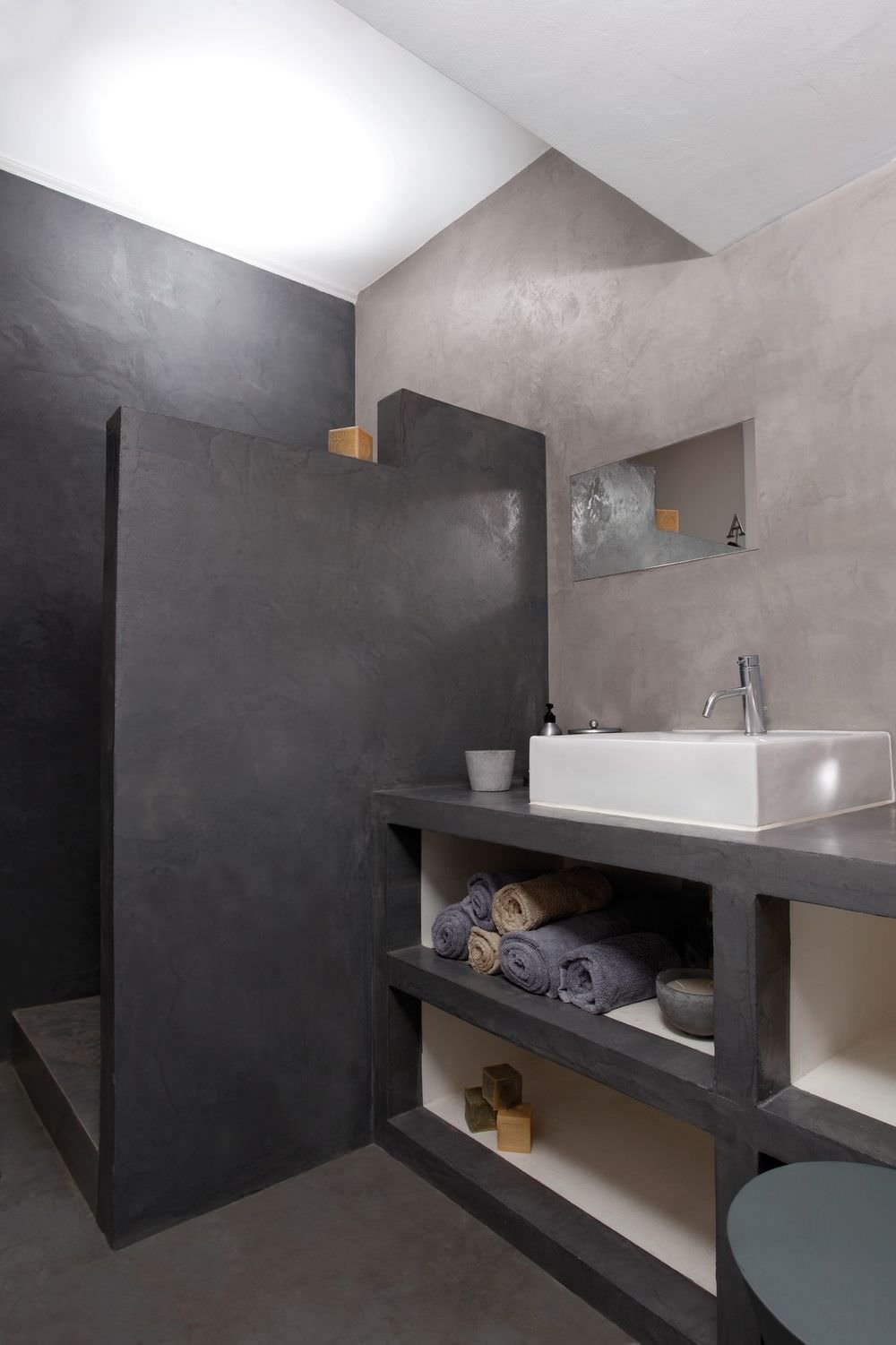 Bagno con pavimenti e rivestimento in resina cementizia in due colori: nero e grigio, per creare uno stile moderno e raffinato