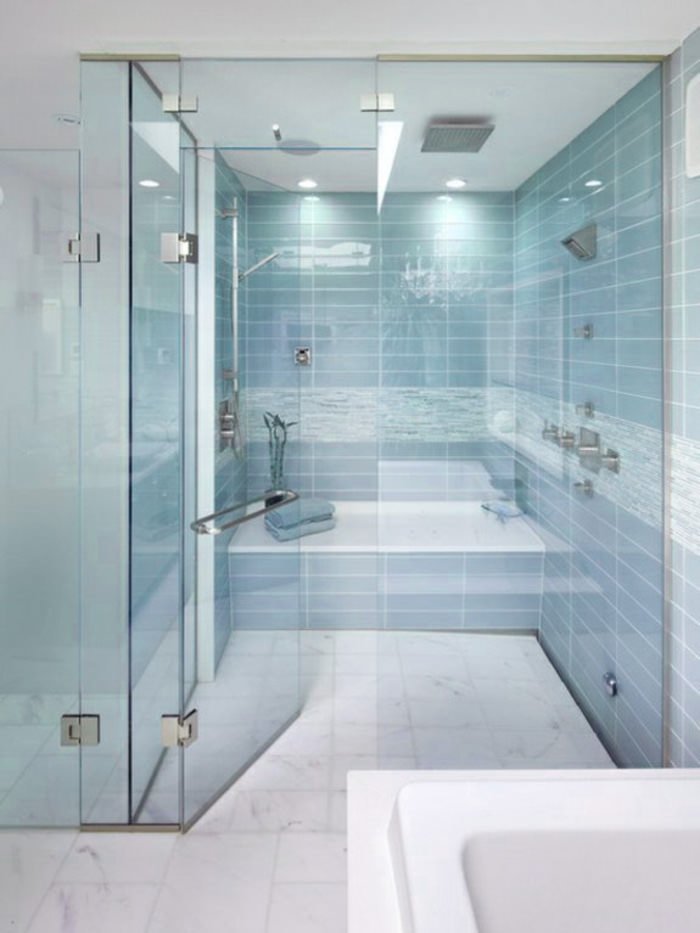 Bagno con piastrelle blu chiaro posate sul muro abbinate perfettamente con il pavimento in marmo di Carrara.