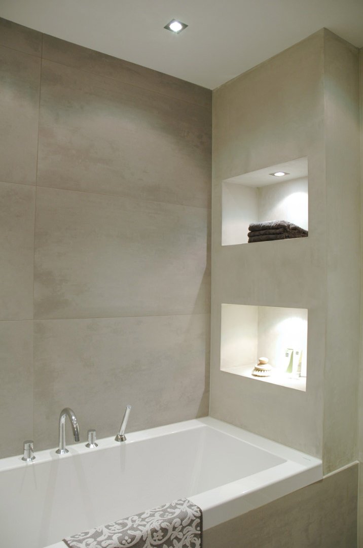 Bathroom image with bathtub and useful niches created in the wall next to it.  Illuminated niche ideas.