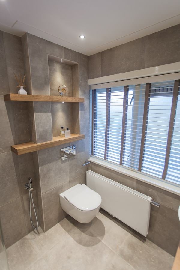 Idea small modern bathroom with floor and wall covering up to the ceiling, in porcelain stoneware tiles.  The glass shower enclosure, flush with the floor.  The wall behind the sanitary ware and the washbasin in the mirror to enlarge the visual space.  Images and inspiration to renovate small bathrooms.