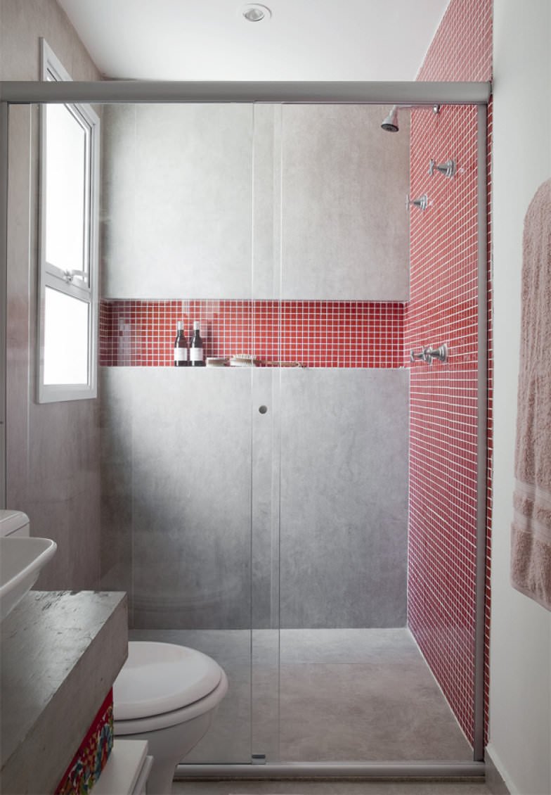 Stanza da bagno stile industrial moderno con pavimento e rivestimento in cemento e la parete della doccia in mosaico rosso porpora, come la rientranza creata su una della pareti. Idee ristrutturazione bagni piccoli.