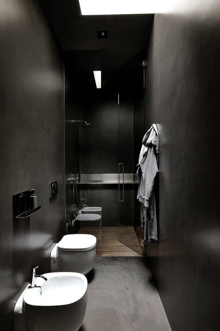 Bagno nero di piccole dimensioni, con pareti, soffitto e pavimento in resina. Sanitari stretti e box doccia con porte in vetro. Stile maschile moderno.