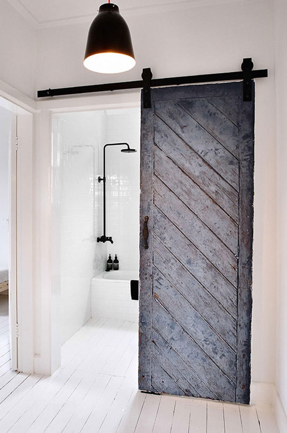 Una porta scorrevole è perfetta per uno bagno piccolo perché non toglie ulteriore spazio. Una veccia porta è stata ricondizionata ed si integra molto bene in questo spazio scandinavo. Idee, soluzioni moderne e costo ristrutturazione bagni piccoli