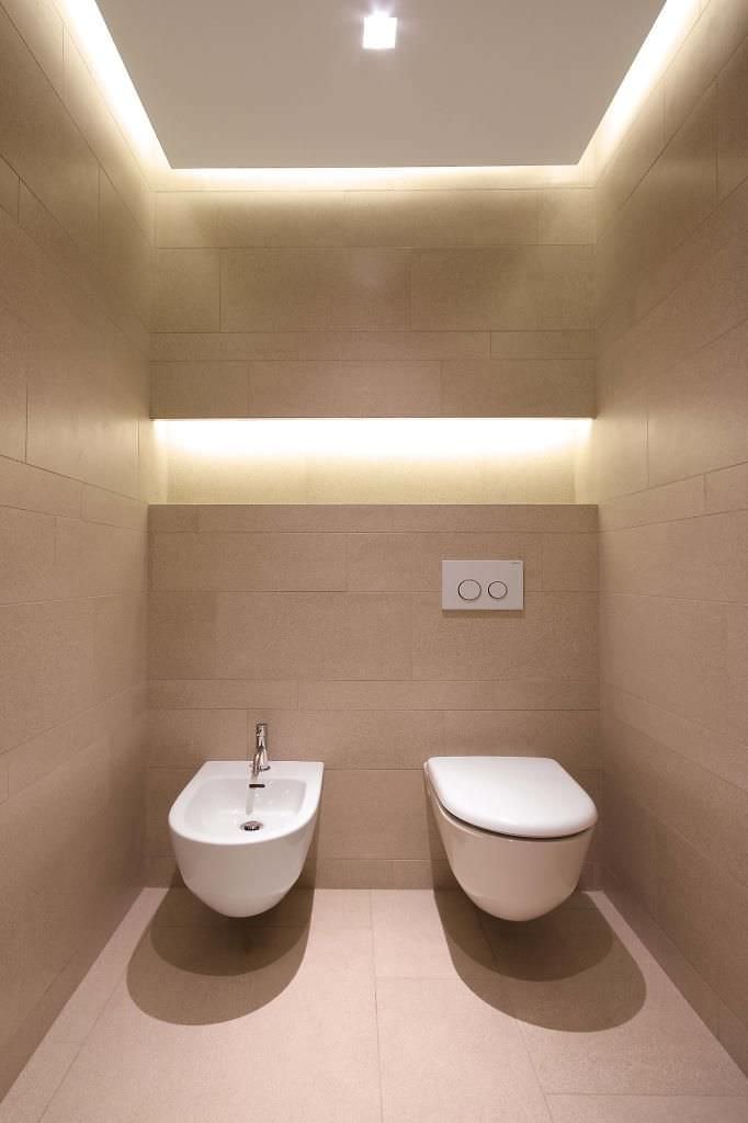 Piccolo bagno, stile moderno con una stupenda illuminazione a led presente nel soffitto in cartongesso e nella nicchia creata sopra i sanitari che rendono lo spazio più grande. Pavimento e rivestimento in piastrelle in gres porcellanato di colore crema.