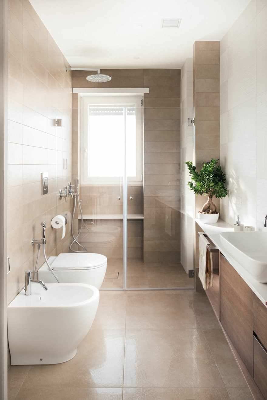 Immagine bagno di dimensioni ridotte con doccia a filo pavimento in fondo alla stanza. Pavimenti e rivestimenti in ceramica di colore marrone chiaro.