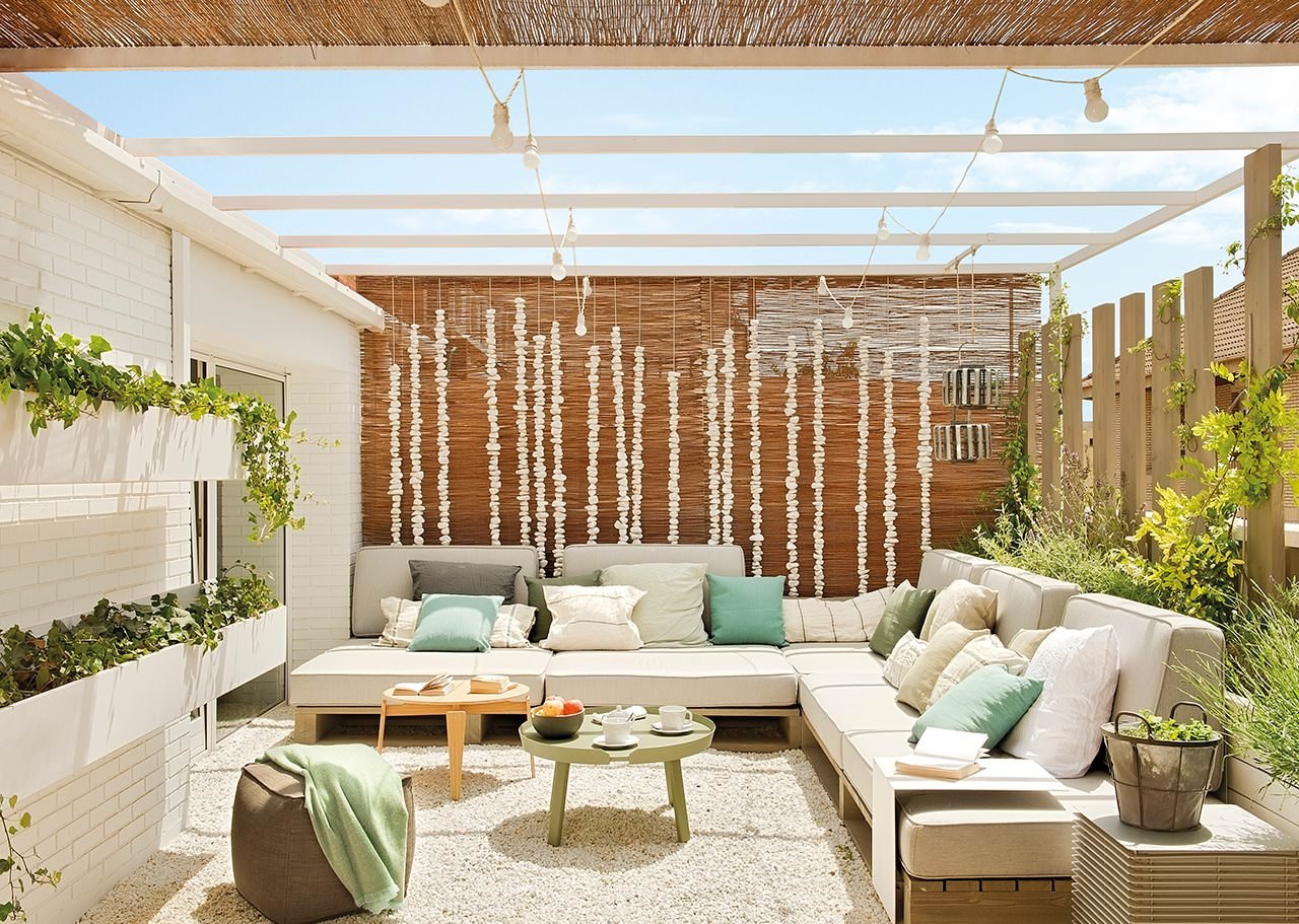 Terrazzo mediterraneo rustico con i pavimenti in ghiaia bianca - supporto per le sedute in pallet e uno stile pulito di grande effetto - idee pavimentazione terrazzi