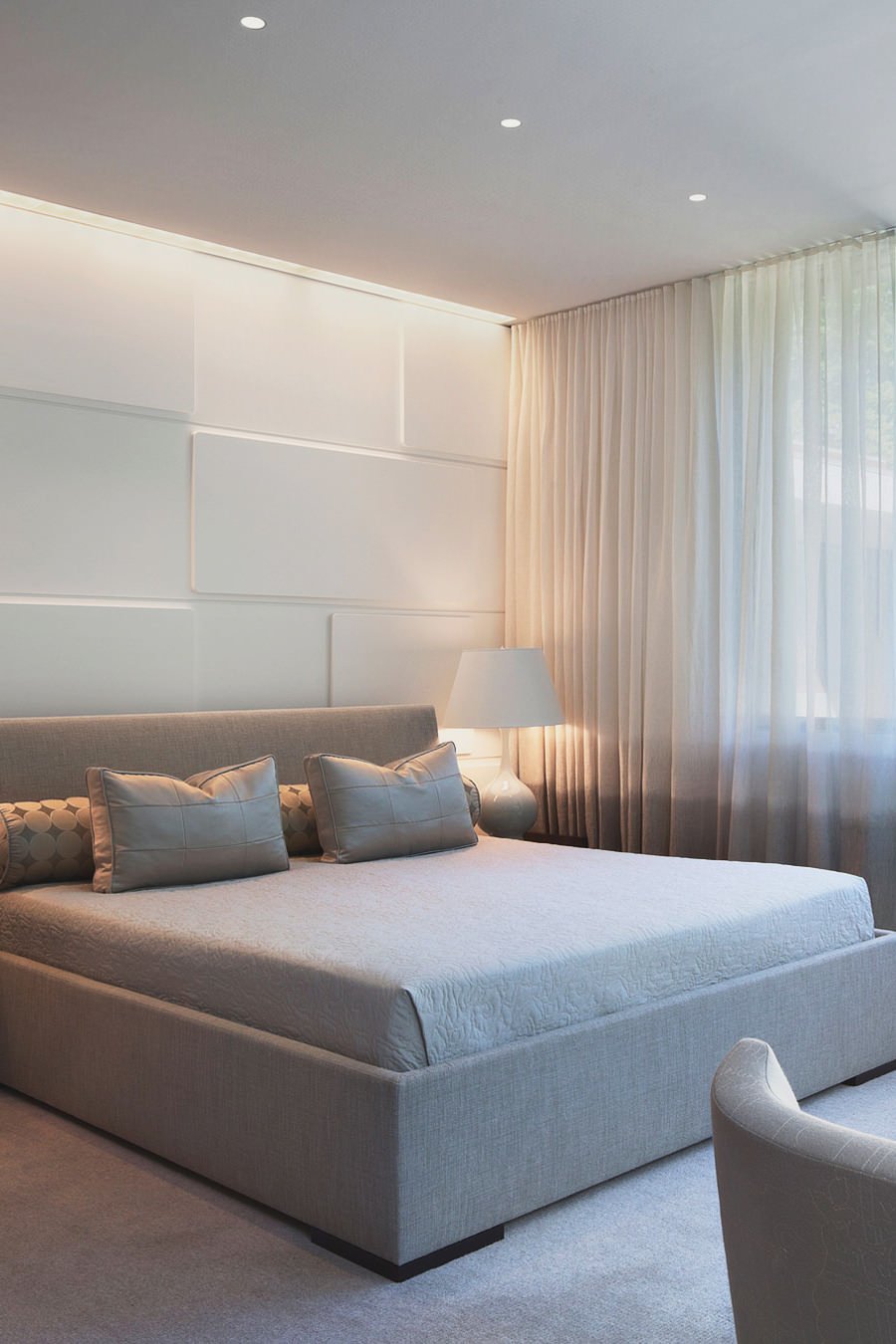 Camera da letto moderna con pareti  rivestiti con pannelli in laminato 3d. La luce diretta dal soffitto crea un originale effetto.