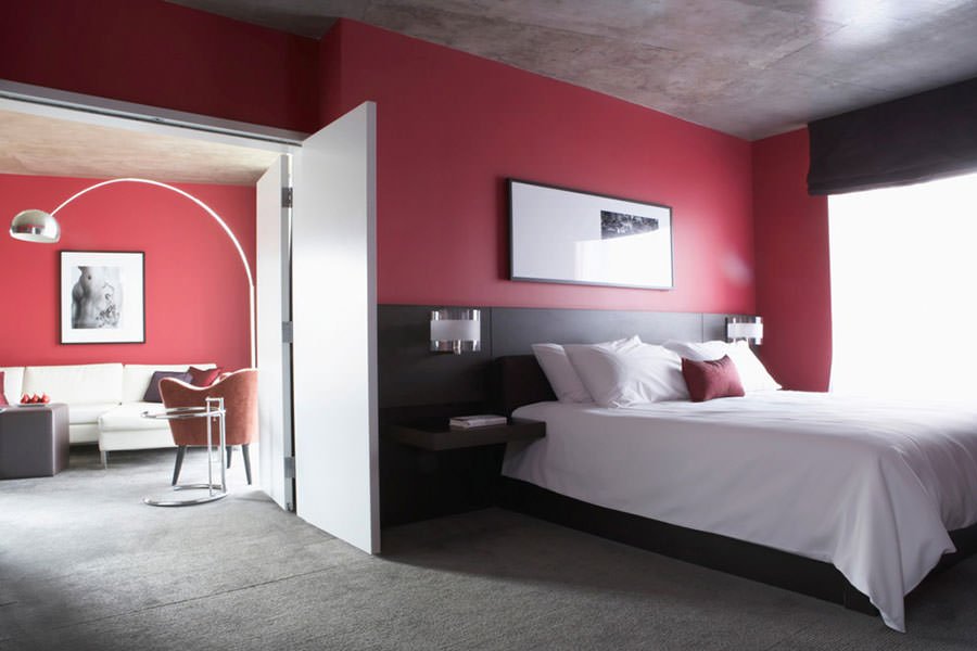 Bedroom with a simple tricolor scoop, red-gray-black, in tech style, classic and modern style together.  Concrete floor and ceiling