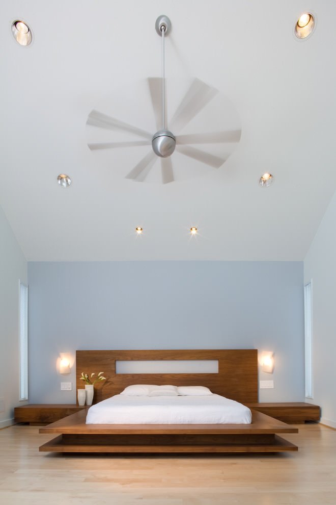 Camera da letto moderna con la parete della testata in blu celeste che sposa perfettamente il parquet sbiancato, chiaro e luminoso - stile contemporaneo moderno