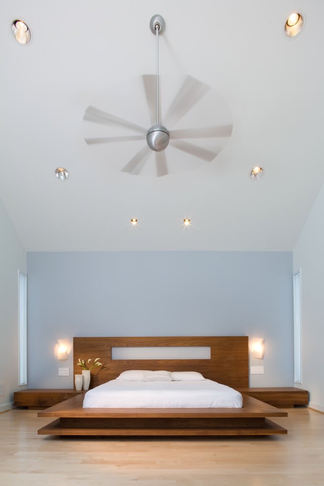 Modern bedroom with a light blue headboard wall that perfectly bleaches light and bright parquet - modern contemporary style