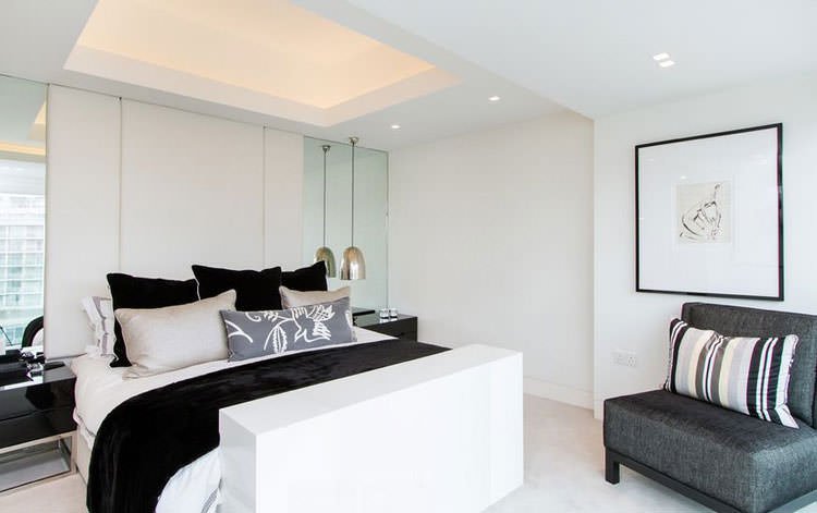 Modern contemporary bedroom image in white, black and gray.  Superb lighting on the plasterboard ceiling and the use of mirrors to enlarge the visual space.