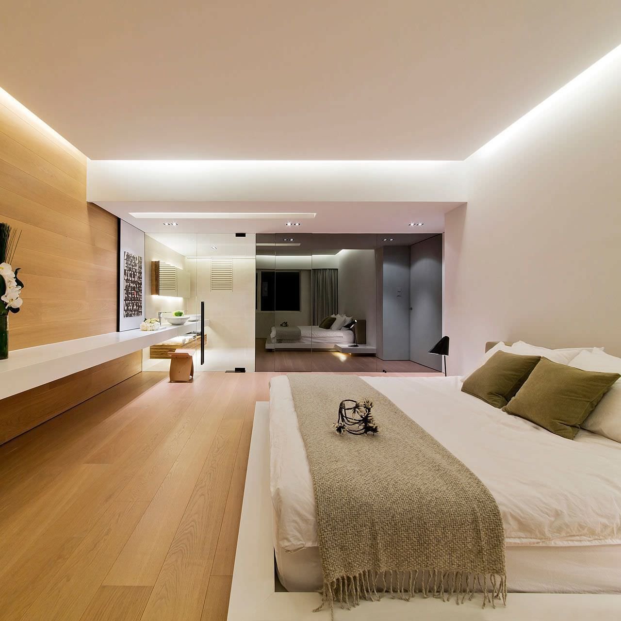 The lighting in the modern bedroom is very interesting.  A led profile was used on the perimeter between area walls and false ceiling.  Floor and wall in parquet strips, white walls and ceiling for good brightness.