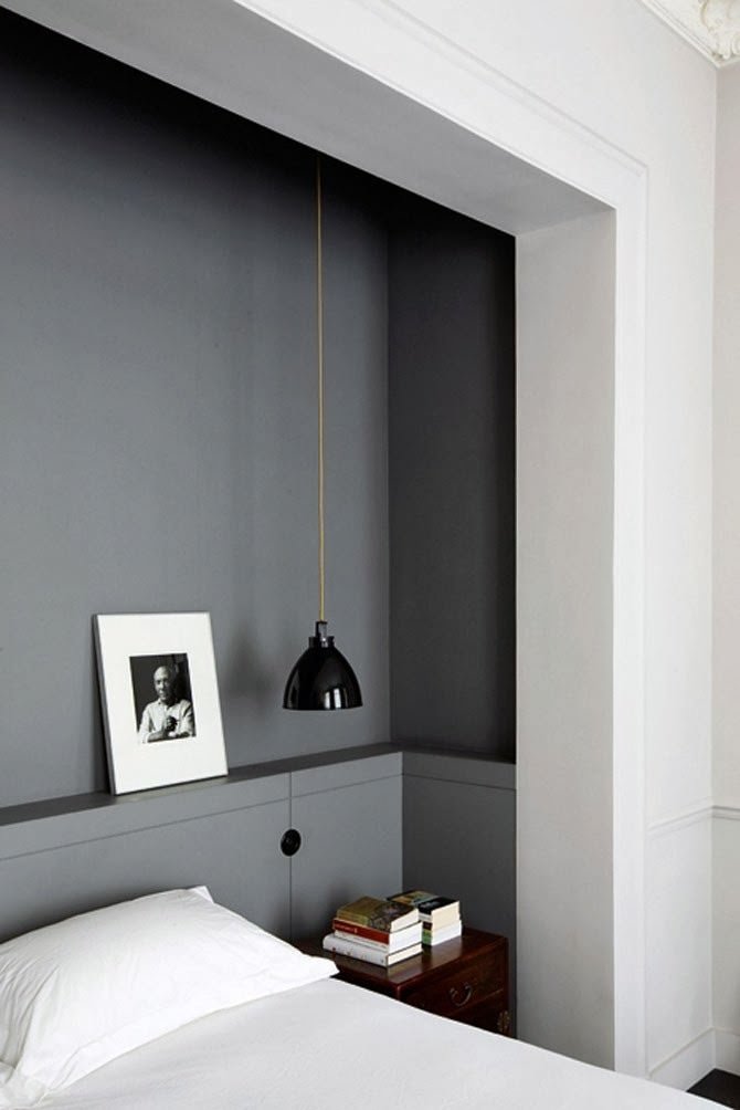 Room with the headboard embedded in the wall.  Thanks to the classic white and gray color scheme and the excavation in the wall, the head seems to open towards a small room in the environment.  Delicacy and grace