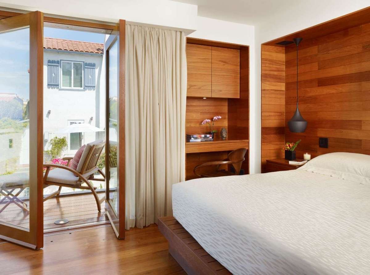 Bedroom image with the headboard embedded in the wall that turns into a small bookcase