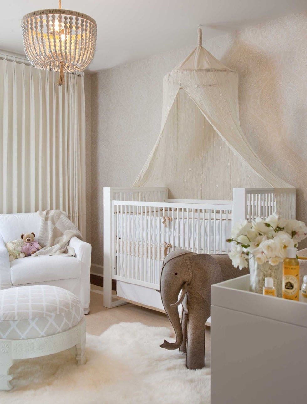 Immagine cameretta da bambini molto elegante, tenui colori rosa e avorio e sofisticato baldacchino per il lettino