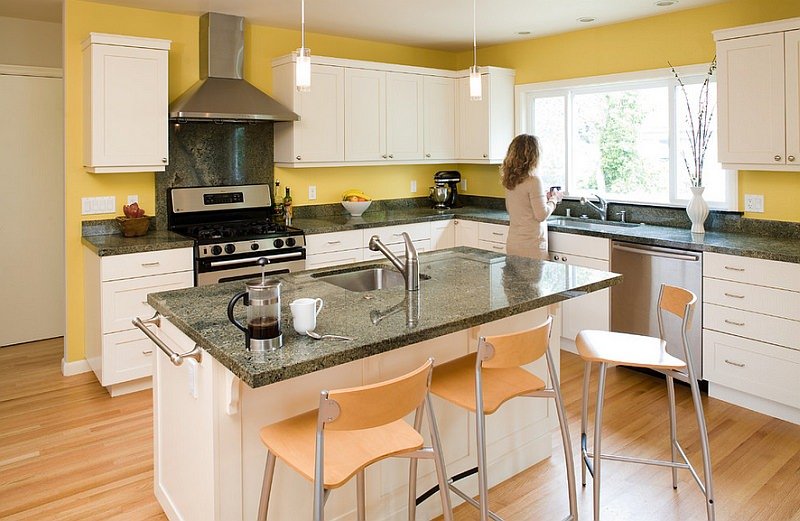 Cucina con le pareti tinteggiate in giallo e mobili di colore bianco - idee paraschizzi per cucine senza piastrelle