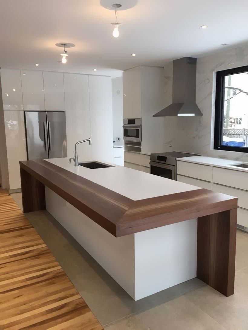 Immagine progetto per cucine con isola e tavolo snack, semplice e di grande effetto. Al modulo bianco in laminato è stato aggiunto una parte in legno che fa da piano d'appoggio.