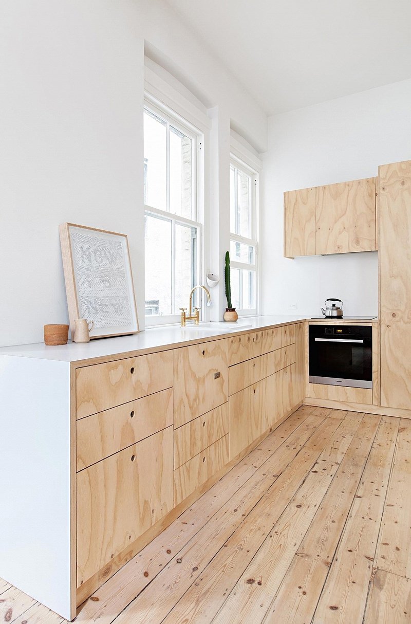 Design cucina in legno molto luminosa ed essenziale. Stile scandinavo. Top in laminato bianco e pavimenti in pino