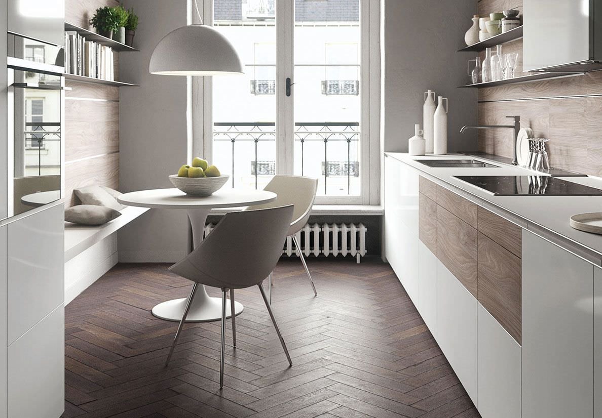 Piccola cucina moderna con mobili in laccato bianco in contrasto con il colore del parquet in legno scuro. Soluzione molto intelligente, la panchina in legno inserita nella parete rivestita in legno.
