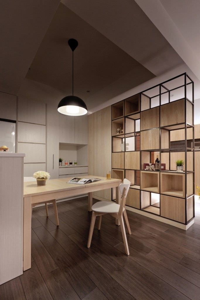 Moderna cucina open space con particolare libreria che delimita l'angolo cottura dal soggiorno. Sono presenti tre essenze di legno.