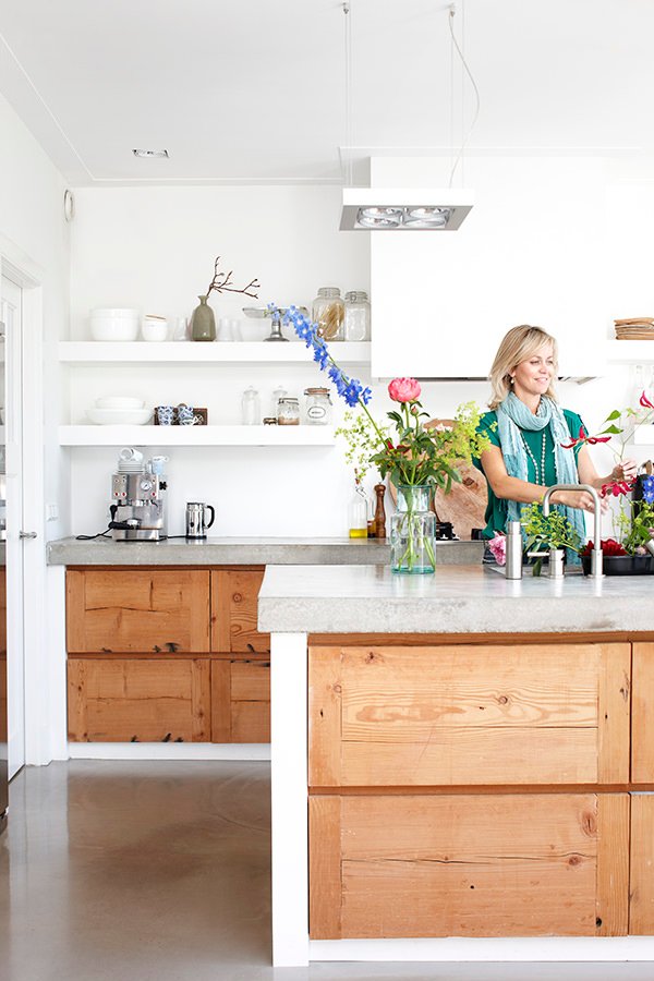 Cucina in muratura stile moderno, semplice e lineare, con isola centrale - top e pavimenti in cemento, sportelli in legno chiaro, pareti bianche - confronto prezzo muratore