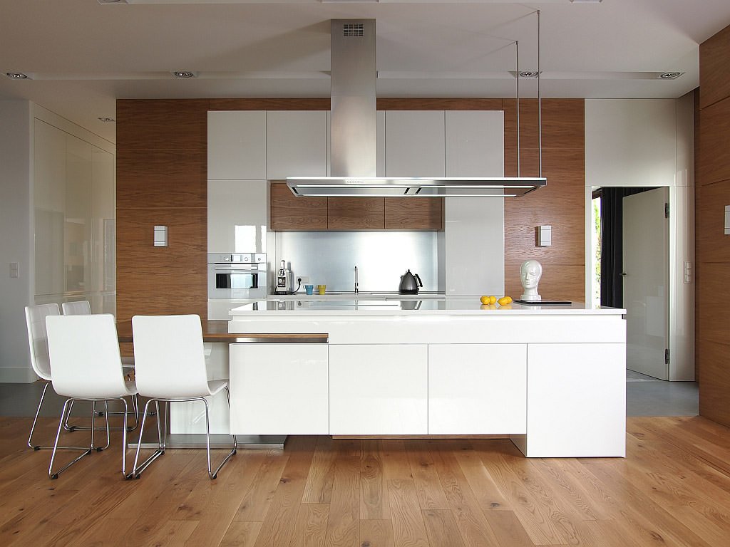 Bellissima cucina moderna elegante e raffinata con pavimento, rivestimento parete e mobili in legno e isola bianca - idee cucine moderne