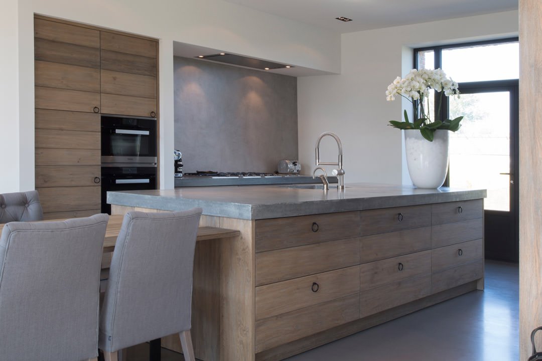 Cucina minimal molto elegante con piano e pavimento in cemento e mobili in massello