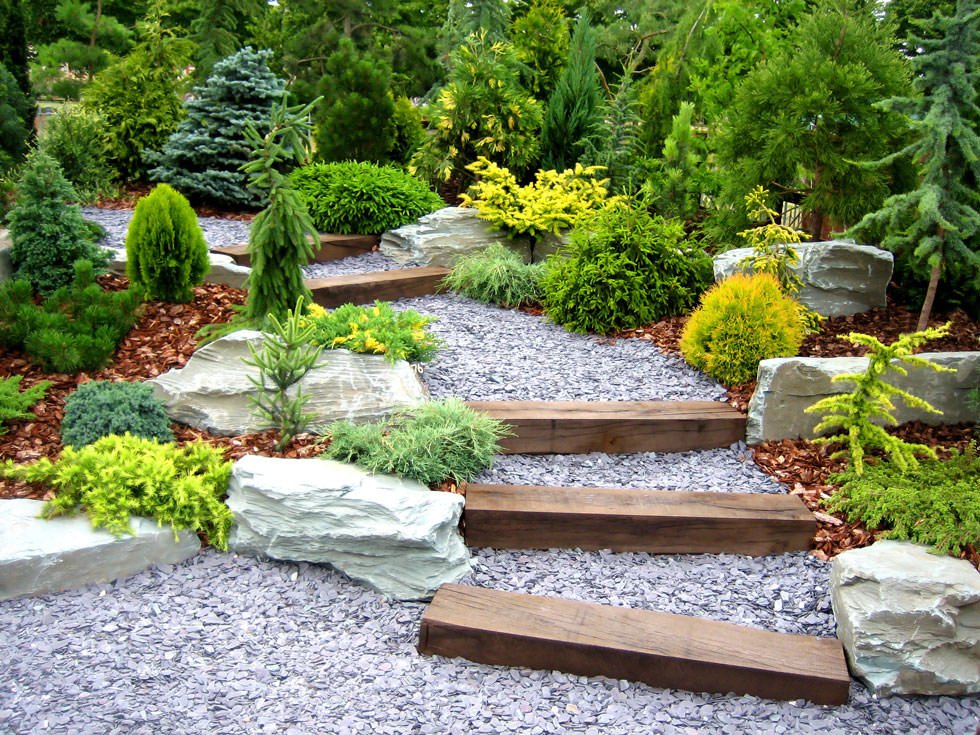 Realizzazione giardini rocciosi in pendenza con scalinata in legno e pietra - idee giardino roccioso