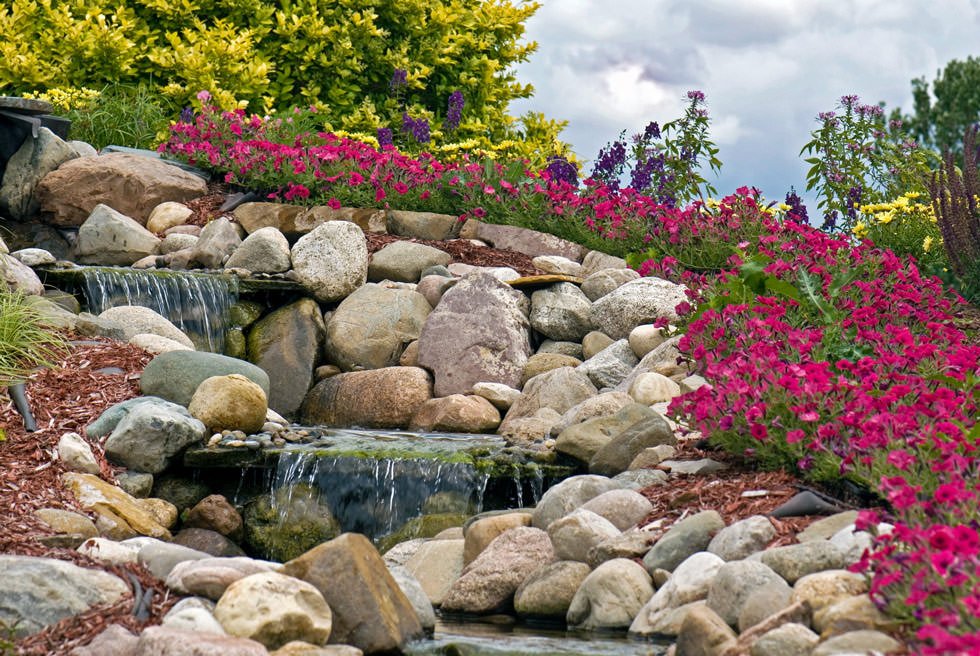Ispirazione per giardini rocciosi con cascata d'acqua - pietre naturali e piante in fiore