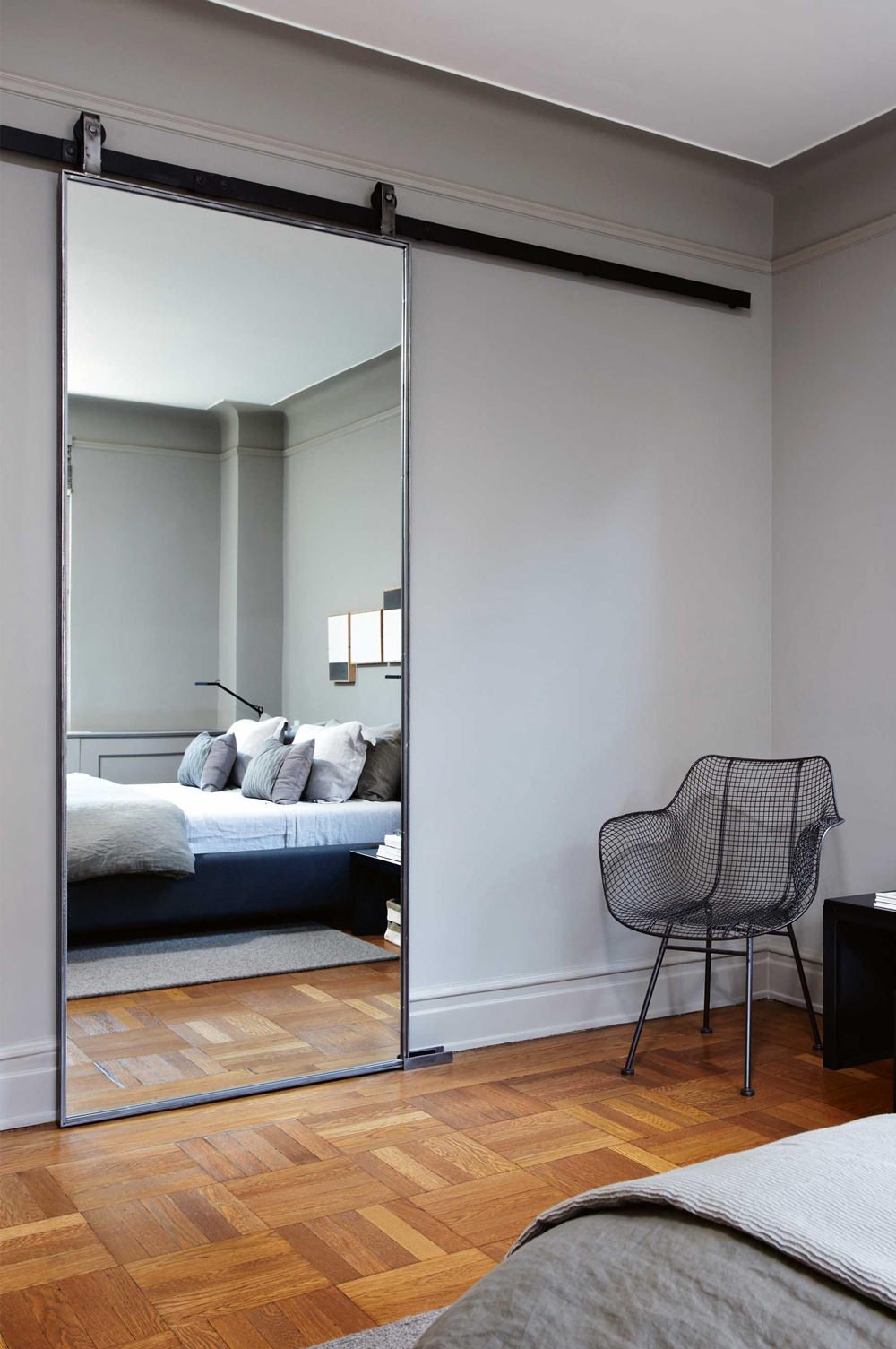 Bellissima idea di porta scorrevole a specchio con scorrimento esterno per dividere il bagno dalla camera da letto - pavimenti in legno, stanza colore grigio tortora