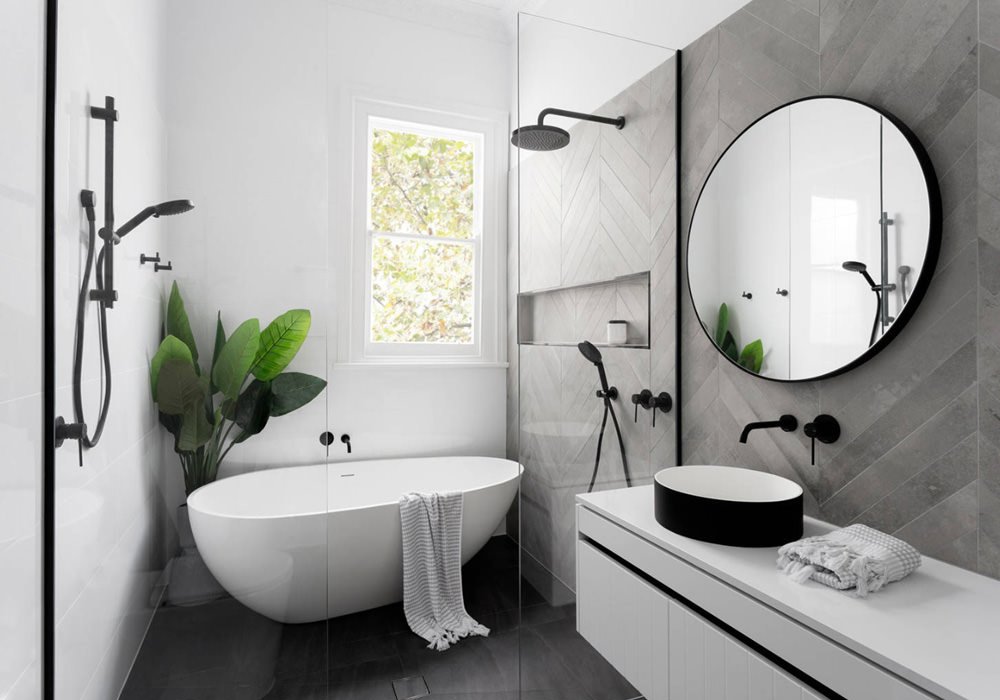 Guida costi ristrutturazione: bagno moderno padronale con vasca e doccia, lavabo a bacinella in bianco e nero, mobile con ante bianche lisce, rivestimento in piastrelle grigie e pavimento in ardesia nera - idee ristrutturare bagni moderni