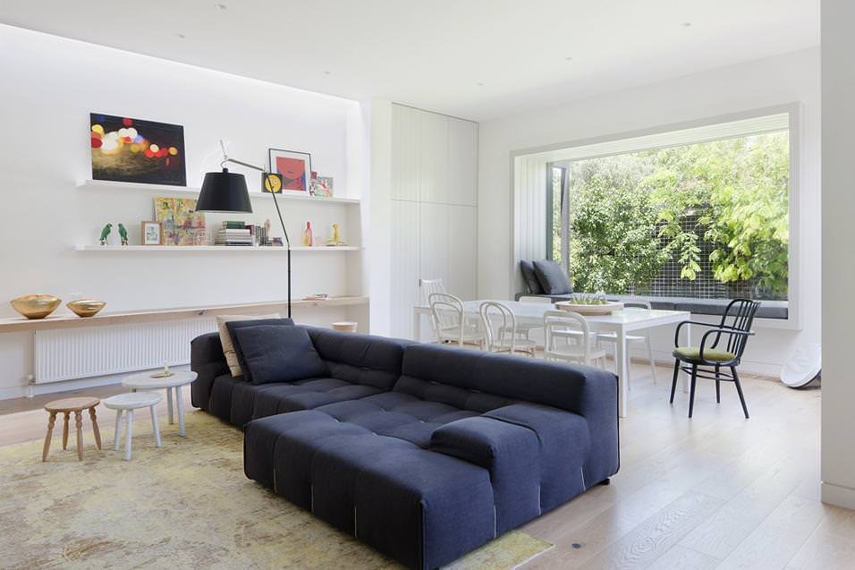 Grande divano blu in ambiente open space per un perfetto angolo lettura in soggiorno moderno