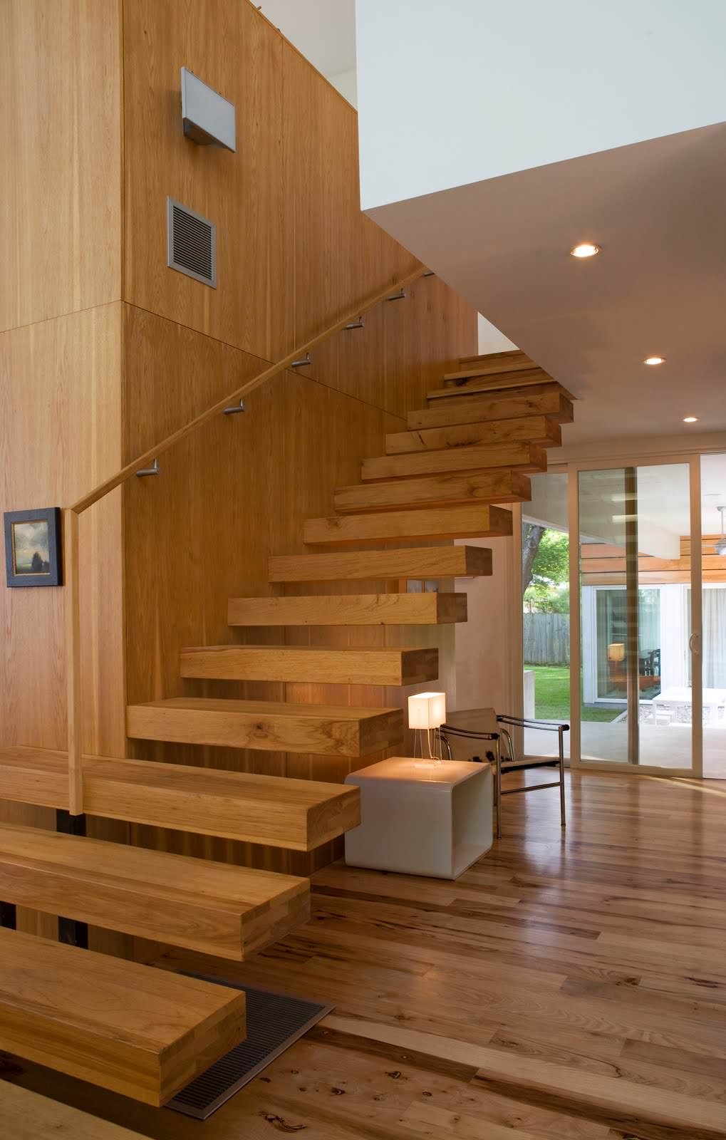 This staircase seems to be part of the wall, both created with the same type of wood.  The supporting structure is located inside the steps and in the wall.