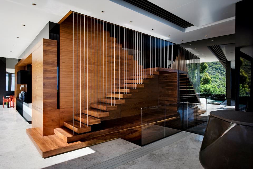 Image of an internal wooden staircase, modern style, anchored to the wall and ceiling with steel rods to create a suspended effect