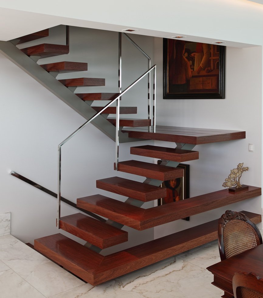 Contemporary oak staircase with a metal beam in the center of the steps.  The first and third floors are transformed into shelves