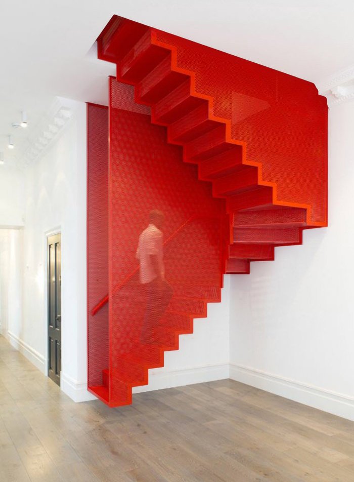 Immagine scala moderna in ferro verniciato rosso, molto particolare, completamente appesa alla struttura dell'edificio esistente - vera sfida di architettura d'interni