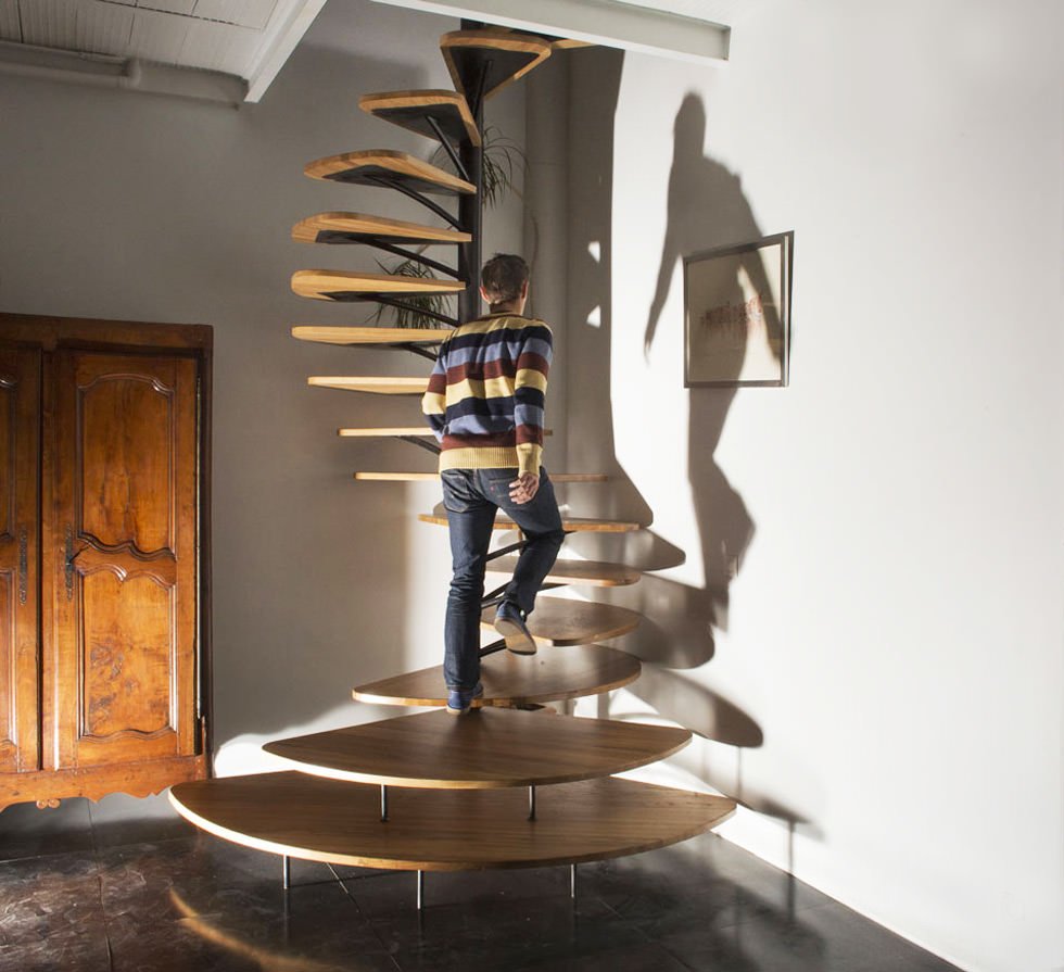 Immagine scala moderna a chiocciola molto bella e graziosa. I gradini in legno hanno la forma dei petali di un fiore e si muovono a spirale attorno ad un palo di metallo