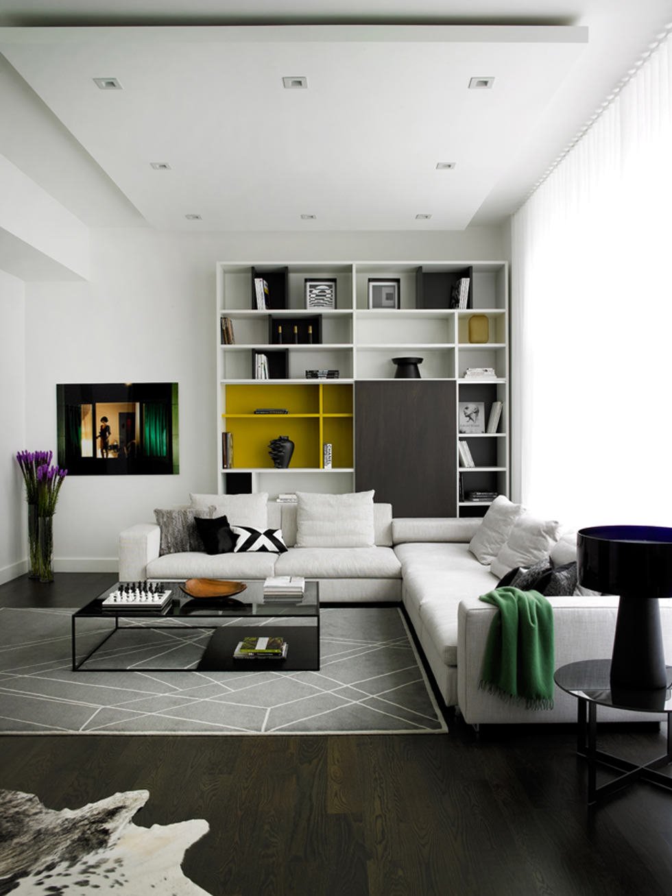 Living contemporaneo moderno molto elegante. Colori dominanti bianco e nero con un tocco di colore giallo all'interno della libreria