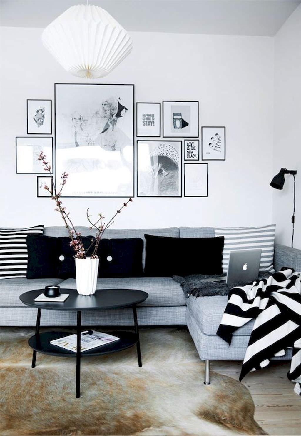 Salotto nordico in tonalità di bianco, nero e grigio, semplice ed essenziale. Pavimento in legno e tappeto in pelle animale, tipico dei paesi nordici