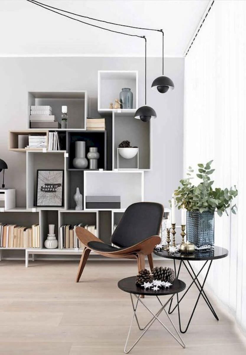 Soggiorno scandinavo moderno molto luminoso, con libreria creata da scatole pensili di geometrie e colori diversi. Disegno essenziale ma di grande impatto