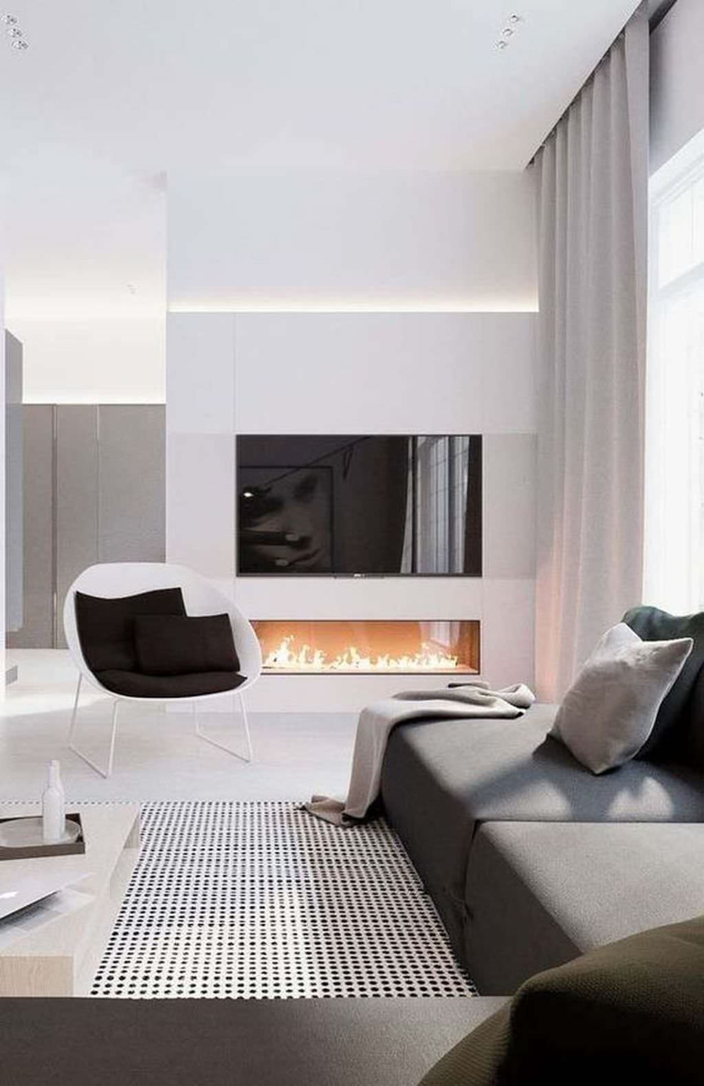 Design living nordico moderno, luminoso ed accogliente, con le geometrie delle forme molto accentuati. Camino a bioetanolo disposto sotto la TV, dalla stessa lunghezza di esso. Luce diffusa sopra questa parete d'accento.