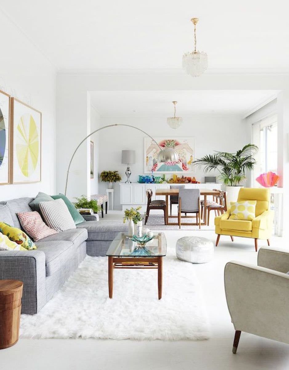 Un particolare soggiorno contemporaneo, stile scandinavo, con pareti e pavimento total white riempito di vita e colore attraverso l'arredamento, le decorazioni e le piante. Le tinte pastello donano allegria e dolcezza all'ambiente.
